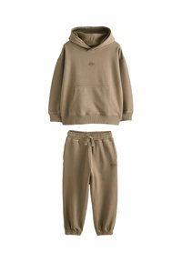 Brun huvtröja och matchande joggbyxor med elastiska ärmslut och dragsko i midjan, med liten broderad logga på bröstet och låret.