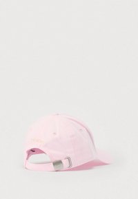 Ροζ βαμβακερό καπέλο μπέιζμπολ με κυρτή γείσο, κεντημένο λογότυπο "TOMMY" σε χρυσό, ρυθμιζόμενο λουράκι με μεταλλικά εξαρτήματα στο πίσω μέρος.