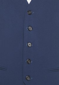 Marineblauer Weste mit glatter Textur, ausgestattet mit sechs schwarzen Knöpfen an der Vorderseite und zwei seitlichen Taschen, in einem maßgeschneiderten Schnitt.