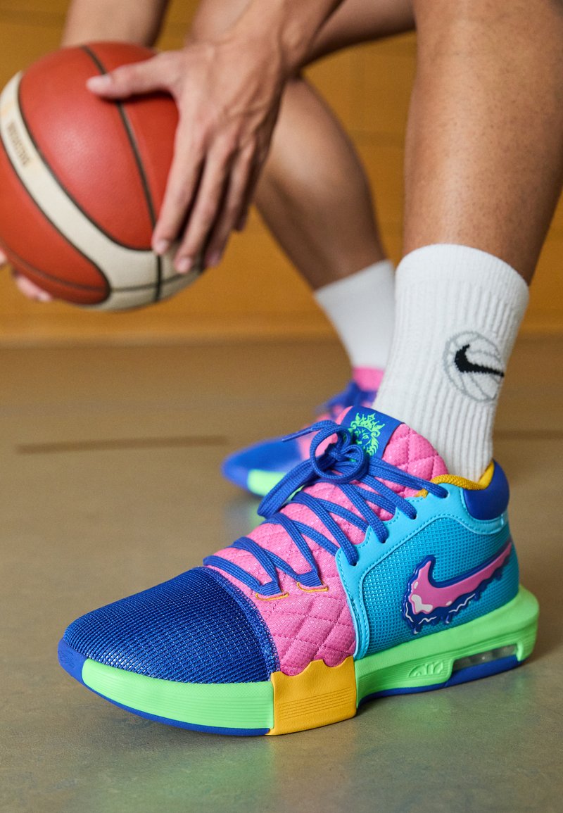 Bunte Basketballschuhe mit einem gesteppten oberen Teil in Pink und Blau, blauen Mesh-Zehen, neongrüner Sohle und gelben Akzenten.