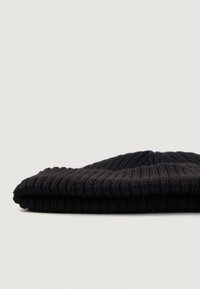 Zwarte geribde beanie met een omgeslagen rand, die een gestructureerd breipatroon en een afgeronde kroonontwerp toont.