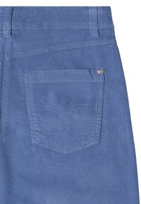 Poche arrière d'un pantalon en velours côtelé bleu avec une double couture et un rivet métallique dans le coin supérieur.