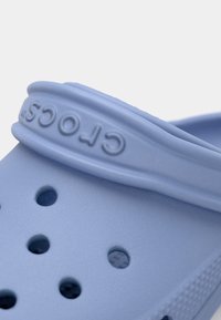Ανοιχτό μπλε Crocs με υφή, που διαθέτουν αεραγωγούς και ανάγλυφο λογότυπο στη λωρίδα. Στρογγυλή μορφή και μαλακό υλικό.