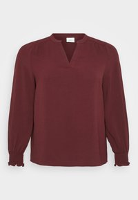 Burgundská blůza s dlouhými rukávy, výstřihem do V, sklady na ramenou a smockovanými manžetami. Vyrobena z texturované, lehké tkaniny.