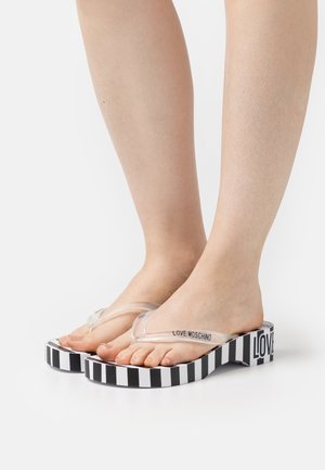 Průhledné plastové žabky se pruhovanou černobílou platformou a nápisem "LOVE MOSCHINO" na boku. Akcentní design na patě.