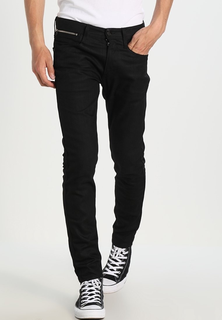 Černé džíny z denimu se slim fit, s kapsami na zip a prošívanými akcenty. Kombinované s černobílými teniskami.