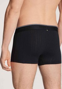 Zwarte boxers met een gestructureerd verticale streep patroon, voorzien van een contrasterende tailleband met merknaam, gemaakt van een rekbare katoenmix.