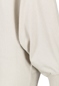 Lichte beige trui met volumineuze puffmouwen, geribde manchetten en een zachte, gestructureerde stof met een gladde afwerking.