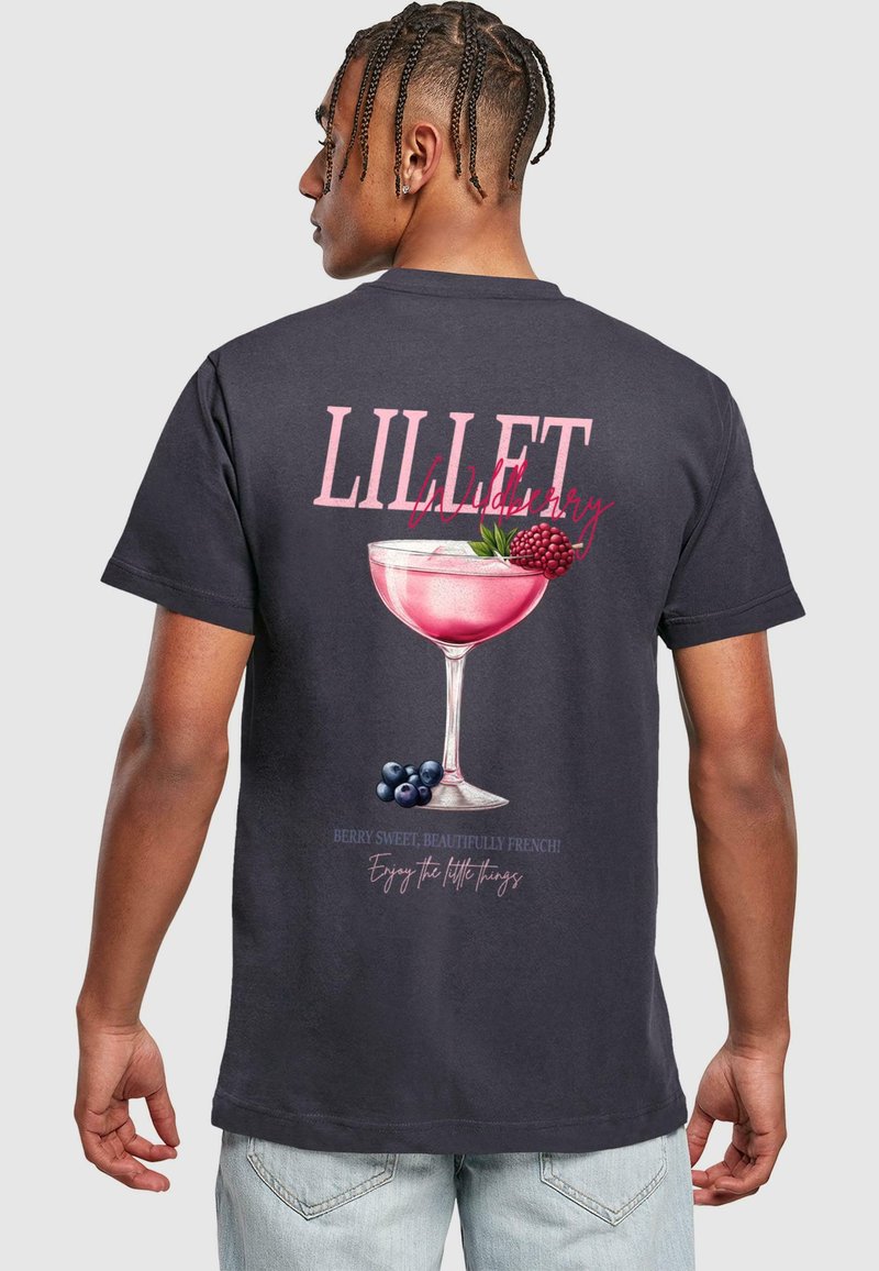 Sort T-shirt med en farverig cocktailglas grafik, der viser pink væske, bær og teksten "LILLET Wildberry" i fede hvide og pink skrifttyper.