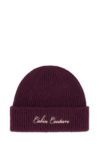 Vinrød strikket lue med ribbestruktur og oppbrettet kant med brodert teksten "Cabin Couture" i lys beige.