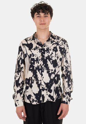 Camicia a maniche lunghe beige con un motivo astratto nero, dotata di colletto classico, patta con bottoni e una vestibilità rilassata. Tessuto dalla consistenza liscia.