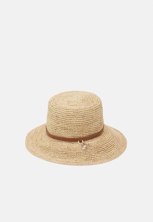 Chapeau de soleil en paille tressée marron clair avec une calotte plate, un large bord et une fine bande en cuir marron ornée d'un petit charme.