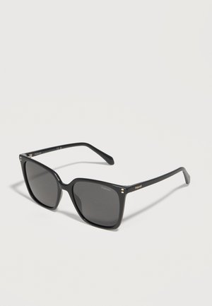 Schwarze Sonnenbrille mit quadratischem Rahmen und dunklen Gläsern, goldfarbenes Polaroid-Logo an den Bügeln und kleine goldene Punktakzente nahe den Scharnieren.