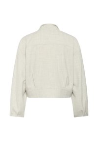 Giacca cropped beige chiaro con maniche lunghe e colletto alto, vista da dietro, presenta una texture sottile e cuciture strutturate.