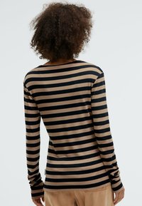 Langärmliges Oberteil mit horizontalen schwarzen und beige Streifen, aus einem weichen, elastischen Material, mit lockerer Passform und rundem Ausschnitt.