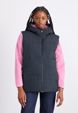 Black puffer vest with a hood, featuring a zip front and quilted design; worn over a pink fleece sweatshirt and dark jeans.