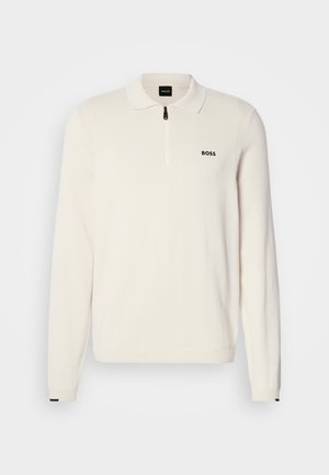 Hvit langermet polo med glidelås krage, med den svarte "BOSS" logoen på brystet og kontrasterende svarte detaljer på mansjettene.