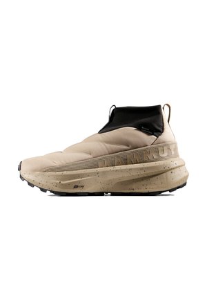 Beiger Slip-On High-Top Sneaker mit schwarzem Knöchelbesatz, dicker gesprenkelter Sohle, strukturiertem Stoff und "MAMMUT" Branding an der Seite.