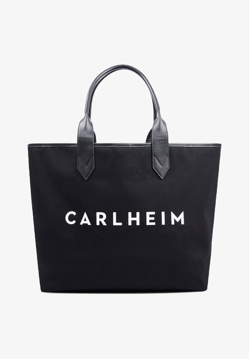 Sac fourre-tout noir avec poignées en cuir et "CARLHEIM" imprimé en lettres capitales blanches sur le devant.