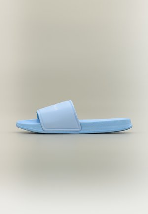 Light blue slip-on slide sandal with a textured sole and wide strap across the foot, on a neutral gradient background.