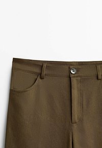 Khaki trousers featuring a woven texture, front pockets, a button fly, and belt loops. The fabric has a smooth finish with a straight-cut design.
