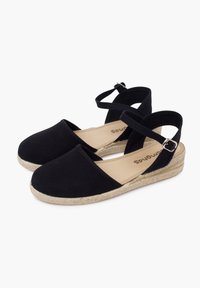 Černé plátěné espadrilky s elastickým páskem kolem kotníku a tkanou jutovou klínovou podrážkou. Mají zaoblenou špičku a plochý podpatek.