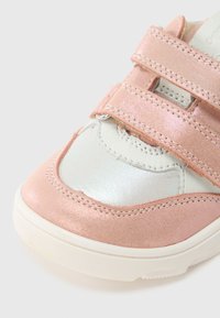 Παιδικό παπούτσι σε ροζ και ασημί με δύο velcro, ανώτερο μέρος από γυαλιστερό δέρμα και υφασμάτινες λεπτομέρειες, στρογγυλή μύτη και λευκή λαστιχένια σόλα.