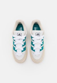 Adidas sporta apavi ar tirkīza samta svītrām, baltām auklām un krēmkrāsas teksturētu zoli. Iekļauts mīksts apkakle un zīmola valnītis.