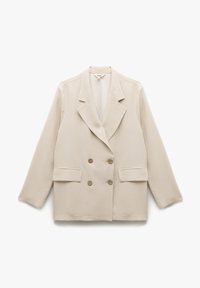 Blazer beige croisé en tissu doux, doté de deux poches avant et de boutons ronds marron, avec un col châle classique.