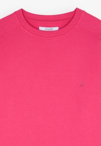 Sweat-shirt à col ras du cou rose vif avec un petit logo brodé tête de mort et os croisés sur la poitrine gauche et une étiquette de la marque Scalpers à l'intérieur du col.