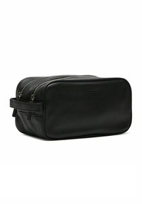 Zwarte leren toilettas met een rechthoekige vorm, uitgerust met dubbele ritsen, een zijhandvat en een textuurafwerking voor duurzaamheid.