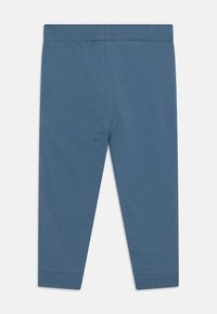 Sinisiä puuvillaleggingssejä, joissa on sileä pinta, leveä joustava vyötärönauha ja tiukat hihansuut. Minimalistinen muotoilu, ilman kuvioita tai koristeita.