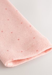 Hele roosa kangas väikeste, laiali jäänud tumedamate roosade täppidega. Servas soonikeline tekstuur, volditud esitamiseks. Pind on sile ja pehme.