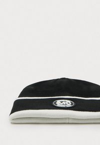 Schwarzer Strickmütze mit einem weißen umgeschlagenen Bund, ausgestattet mit einem runden Logo-Patch. Glatte Textur und simples Streifendesign am Rand.