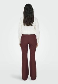 ONLY MIT WEITEM BEINSCHNITT TRAVEL MITTLERE TAILLE AUSGESTELLT - Pantaloni - red mahogany