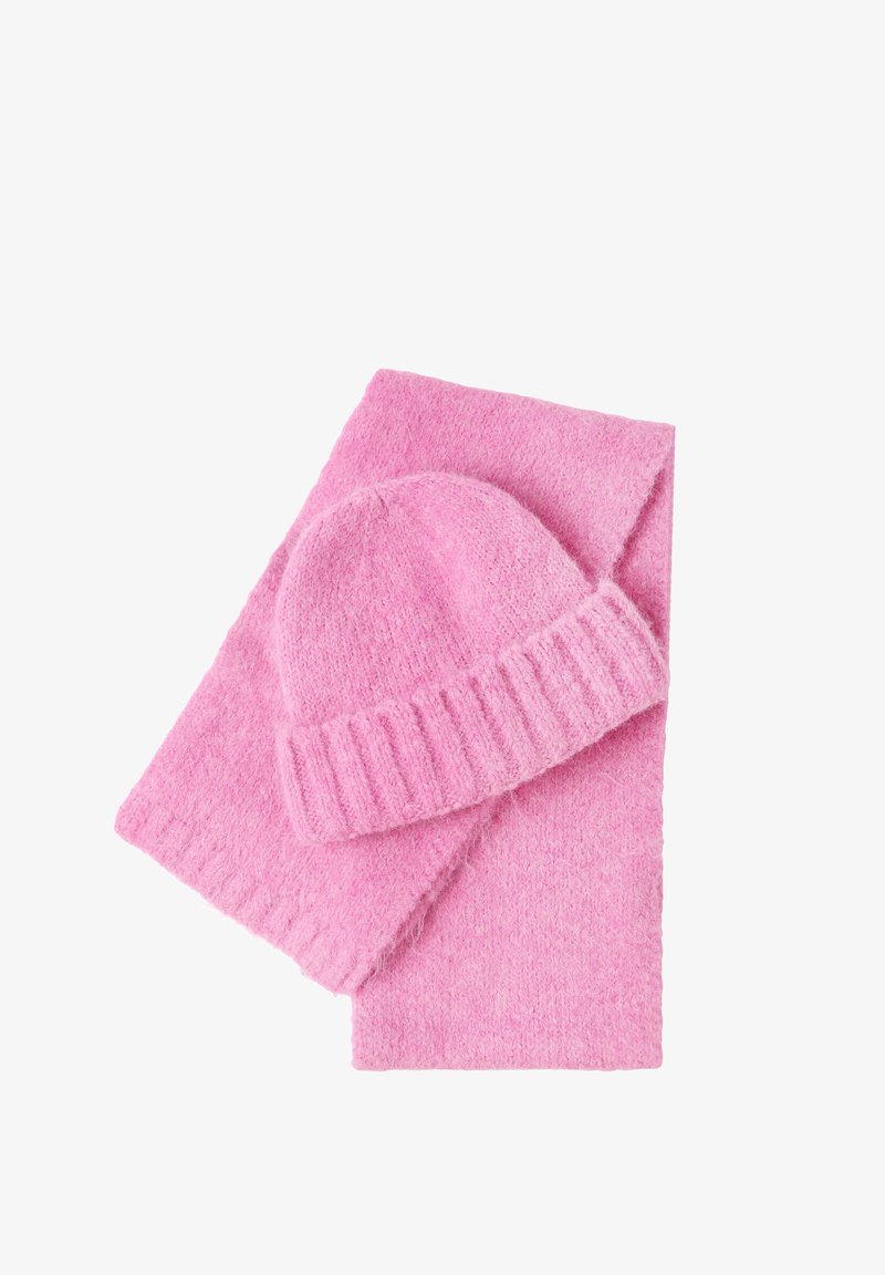 Ensemble de bonnet et écharpe en laine rose. Le bonnet présente une bande côtelée ; les deux articles ont une texture douce et une finition uniforme et duveteuse.