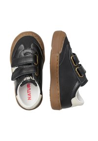 Scarpe per bambini in pelle nera con due fasce in Velcro, dettagli bianchi e suola in gomma marrone; punta arrotondata e interno imbottito.