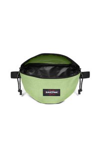 Grön tygväska med en rundad form, kontrasterande svart innerfoder och dragsko-stängning. Har en Eastpak-logotyp på framsidan.