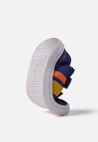 Botte d'enfant bleue et jaune avec des rayures orange, bande velcro, col rembourré et semelle en caoutchouc blanc texturé, vue en angle.