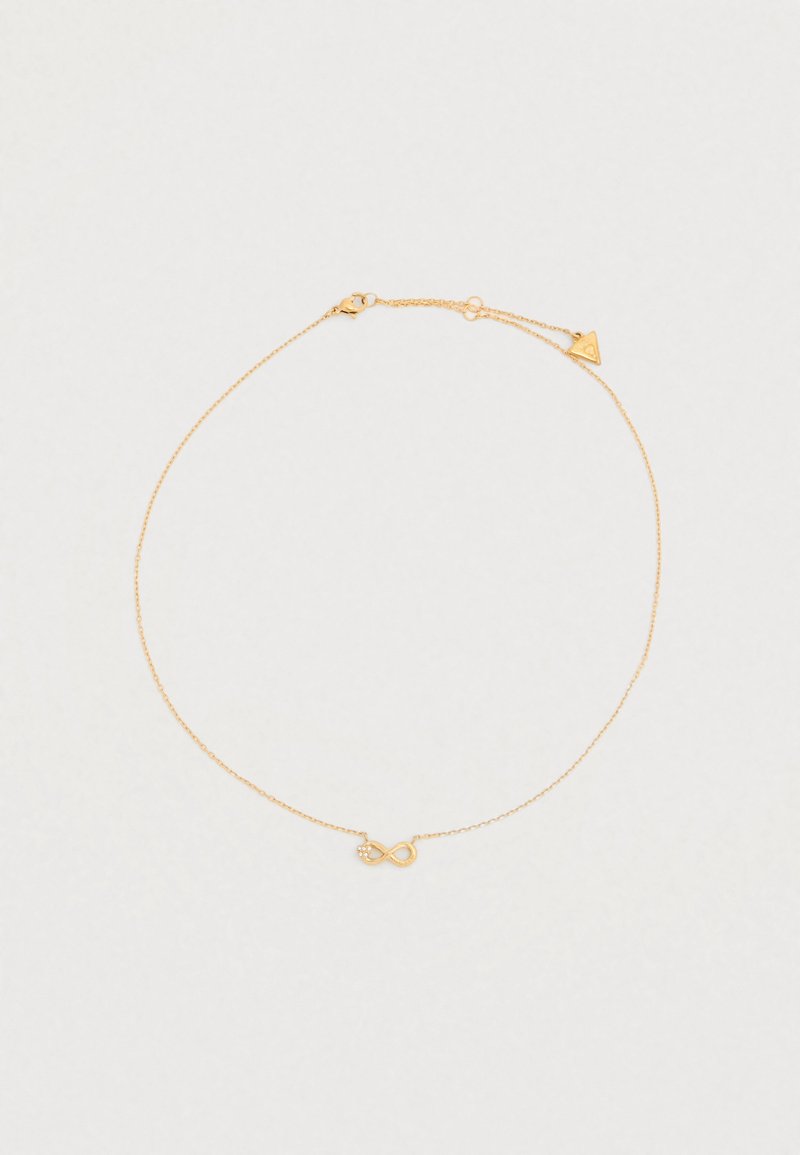 Bracelet de couleur or avec une chaîne délicate, agrémenté d'un symbole d'infini et d'un petit pendentif triangulaire près du fermoir.