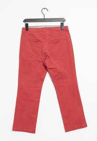 Rode katoenen broek die aan een zwarte hanger hangt, met twee achterzakken en een rechtogen ontwerp met zichtbare stikseldetails.