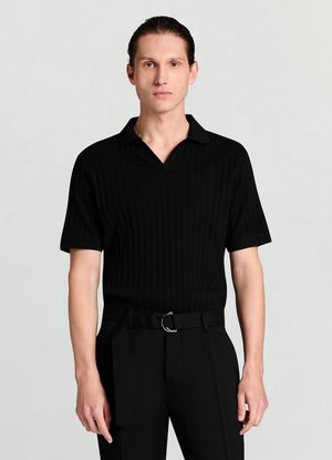 Polo noir côtelé avec un col en V et des manches courtes, doté d'un tissu texturé. Associé à un pantalon noir ajusté et une ceinture.