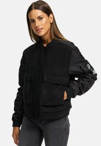 Black bomber jacket featuring wool blend front, satin sleeves, two front pockets, and ribbed cuffs. Smooth texture with a structured fit.