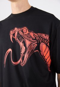 Black cotton t-shirt featuring a large red graphic of a snake's head with open jaws, detailed scales, and a protruding tongue.