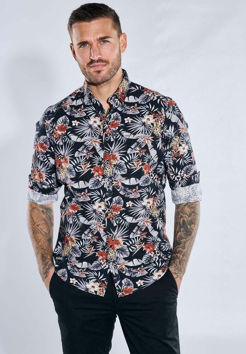 Kurzarmhemd aus schwarzem Stoff mit einem bunten Blumen- und Blattmuster, mit umgeschlagenen Ärmeln und einer Knopfleiste.