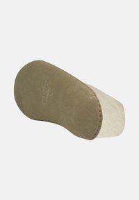 Lys beige slippers med en blød suede overflade, rund tå og en søm langs bunden. Flad gummisål for bedre greb.