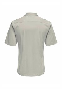 Polo majica kratkih rukava, svijetlosiva, s klasičnim ovratnikom, glatkom teksturom i dizajnom stražnjeg dijela. Minimalni detalji na tkanini.