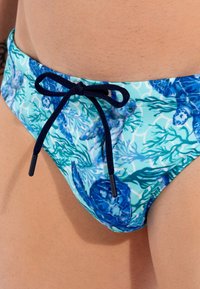 Bikini-Unterteil aus dehnbarem Stoff mit einem blauen aquatischen Muster. Mit einem navy-blauen Kordelzug zur Anpassung an der Taille.