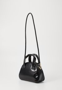 Schwarze lackleder Handtasche mit runder Form, zwei kurzen Griffen und einem langen, dünnen verstellbaren Trageriemen, ausgestattet mit einem goldenen Reißverschluss.