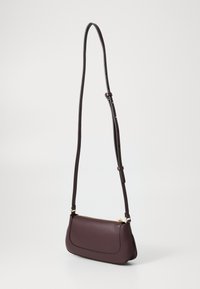 Braune Leder-Crossbody-Tasche mit einer geschwungenen Form, goldfarbenem Reißverschluss und verstellbarem Tragegurt. Sie hat eine glatte Textur und dezente Steppnähte.